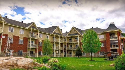 Un grand immeuble d'appartements avec une pelouse devant lui