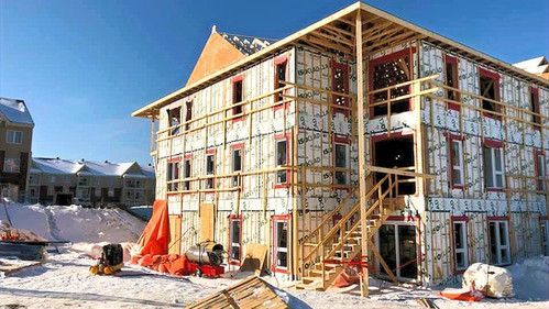 Un grand bâtiment est en construction sous la neige.