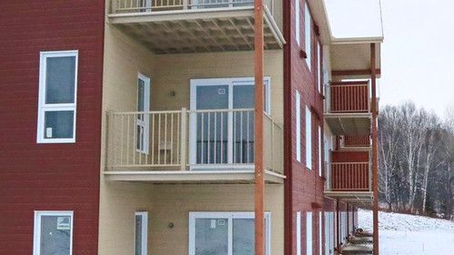 Un grand immeuble d'appartements avec beaucoup de fenêtres et de balcons.