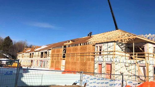 Un grand bâtiment en construction avec une grue au sommet.