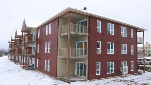 Un grand bâtiment rouge avec beaucoup de fenêtres et de balcons