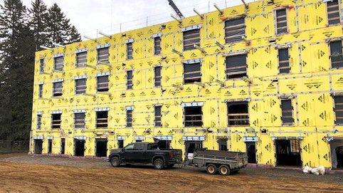 Un camion est garé devant un bâtiment en construction.