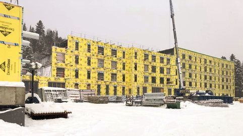 Un grand bâtiment est en construction sous la neige.