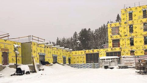 Un grand bâtiment est en construction sous la neige.