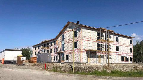Un grand bâtiment est en construction au milieu d'un champ.