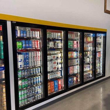 Un réfrigérateur rempli de canettes et de bouteilles de bière.