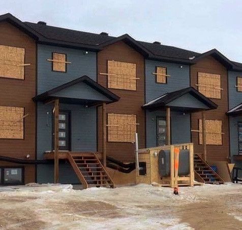 Une rangée de maisons en construction avec des fenêtres condamnées.