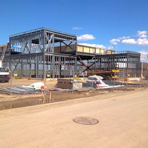 Un grand bâtiment est en construction sur un chemin de terre
