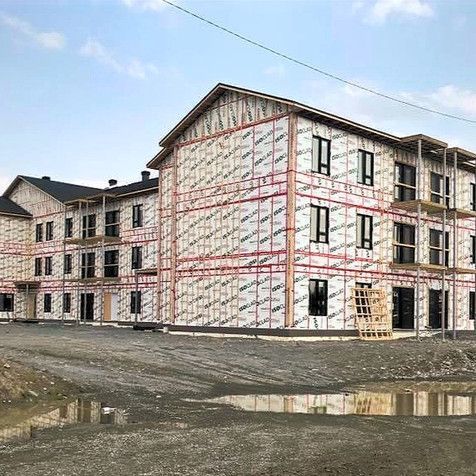 Un grand bâtiment en construction avec beaucoup de fenêtres et d'échafaudages.