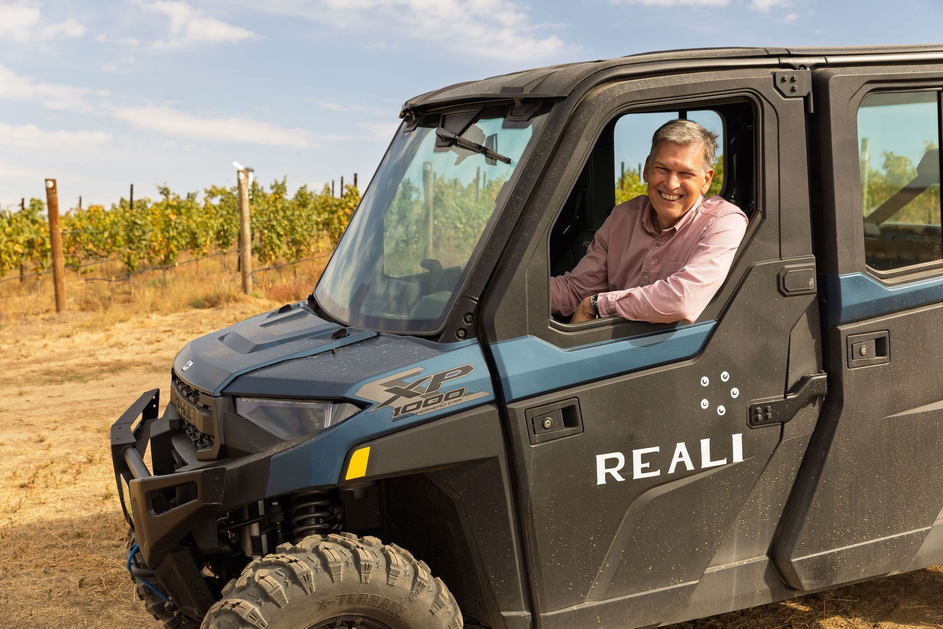 Ken Reali driving a REALI car through the vineyard