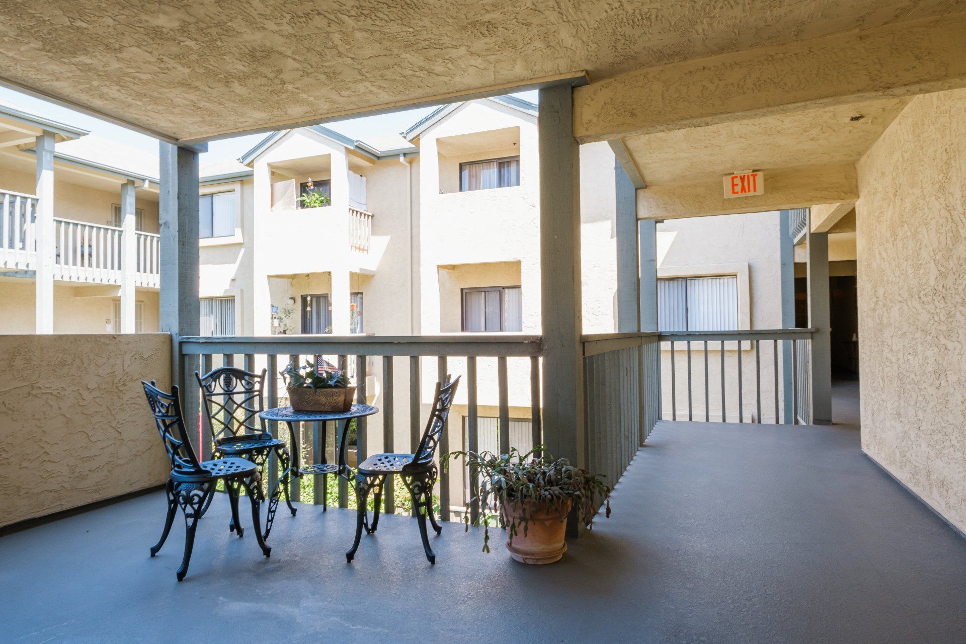 A balcony with a table and chairs in front of a building