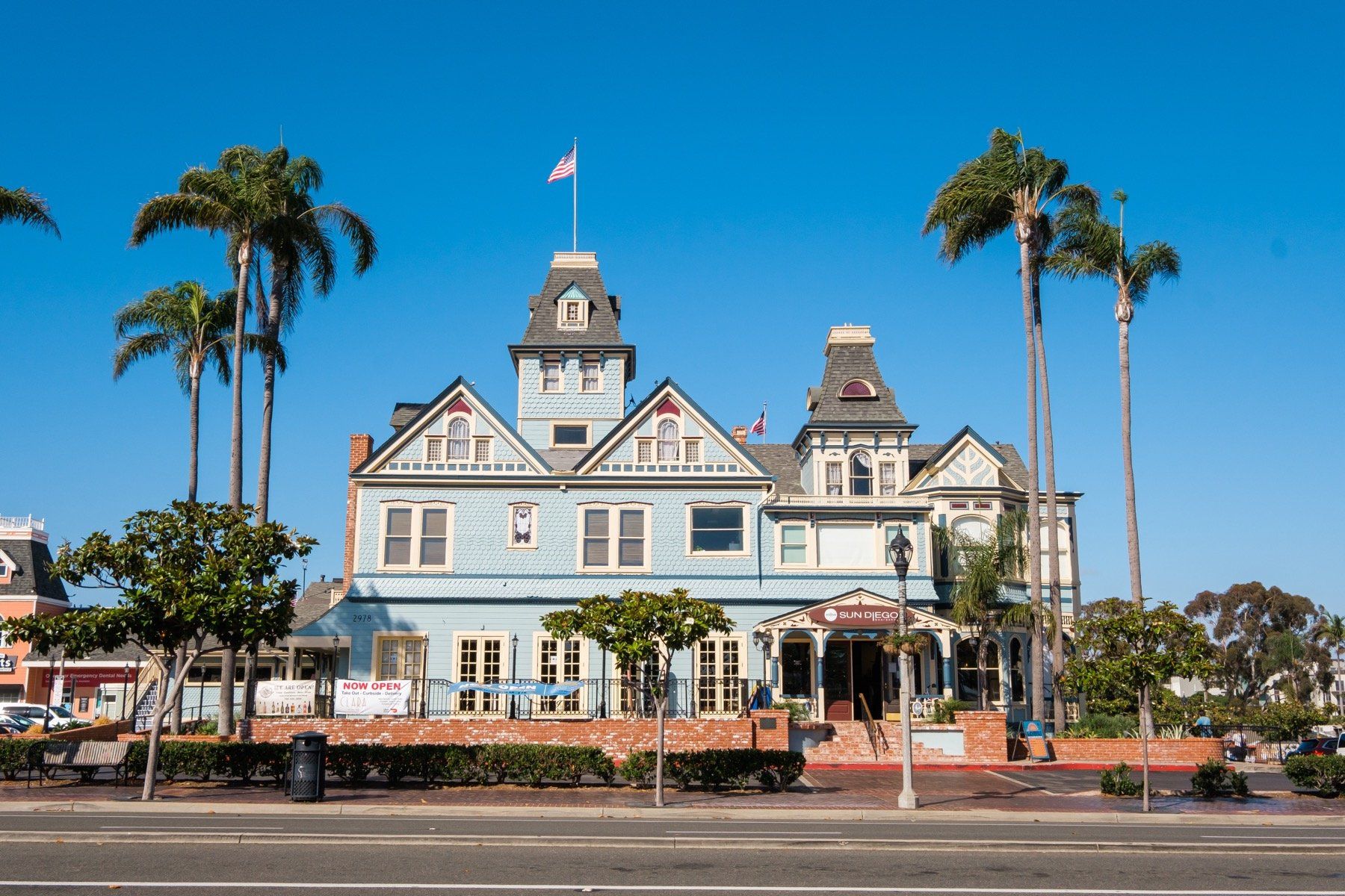A large blue building with palm trees in front of it.
