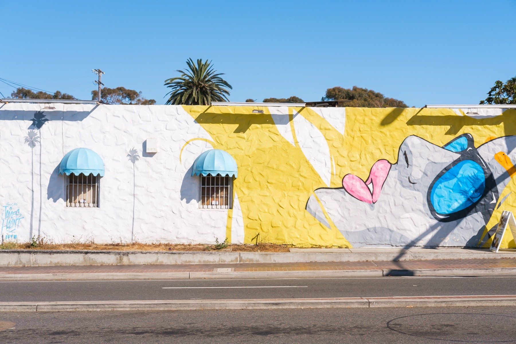 A mural on the side of a building shows a woman with a heart in her mouth.