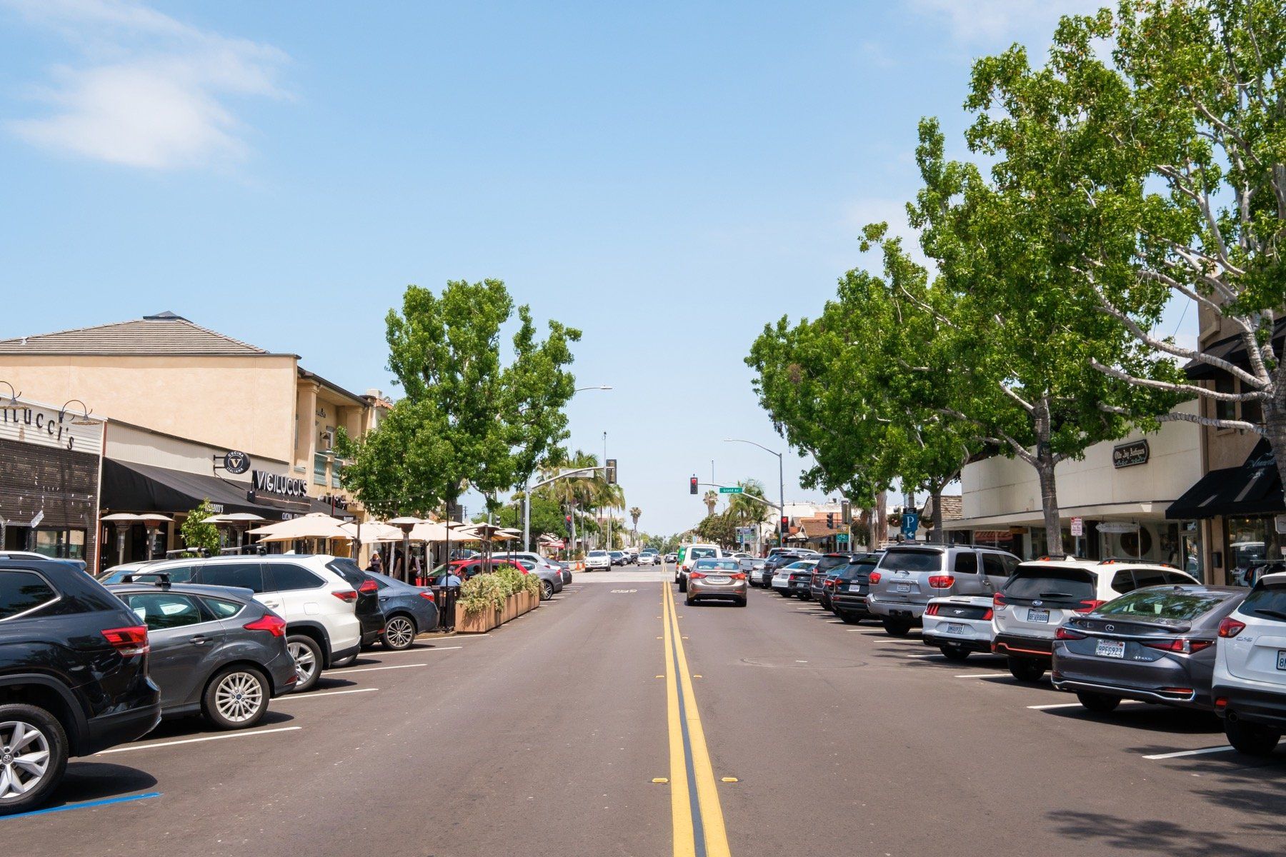 A row of cars are parked on the side of a street.