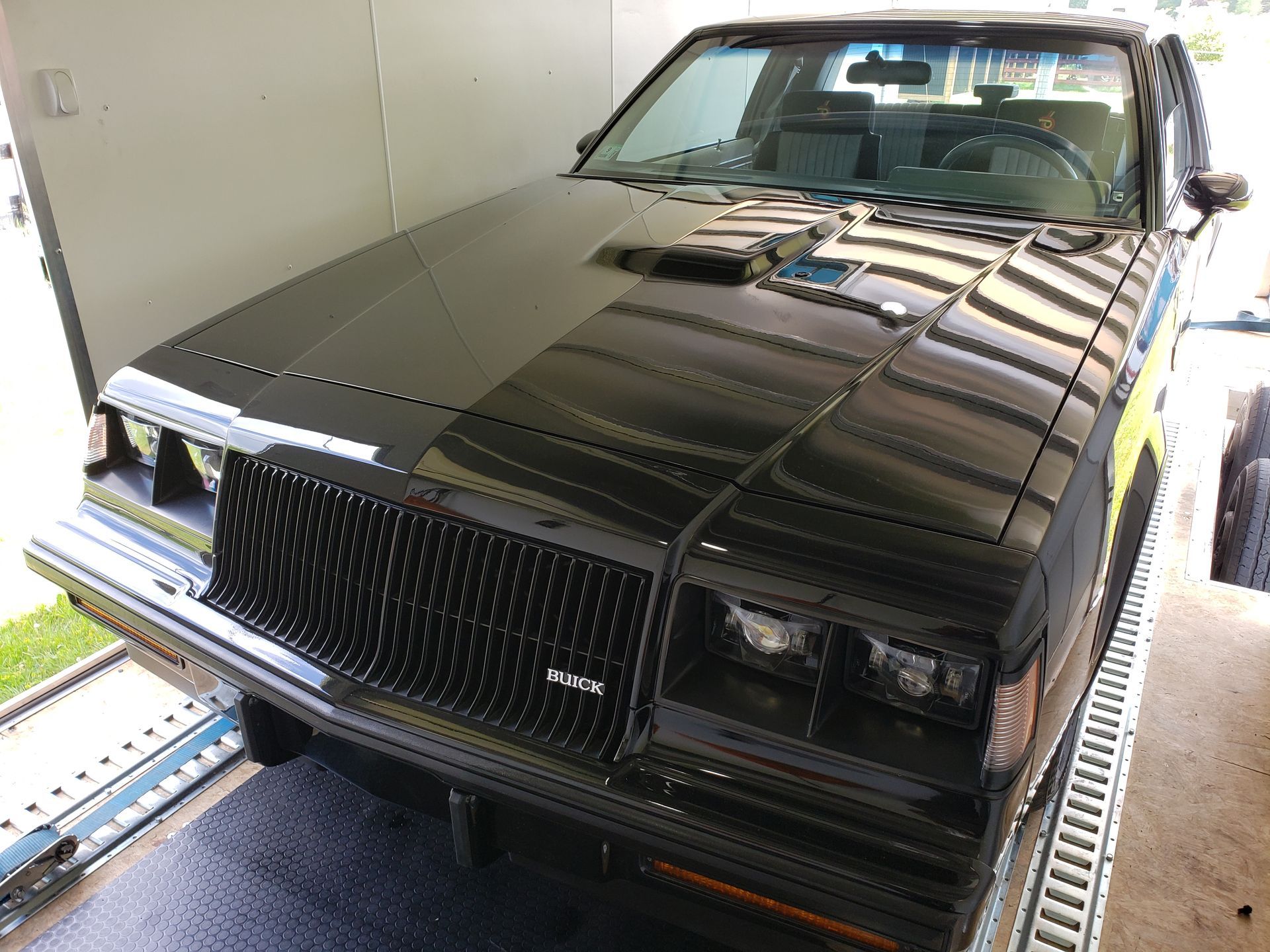 A black car is parked in front of a trailer.