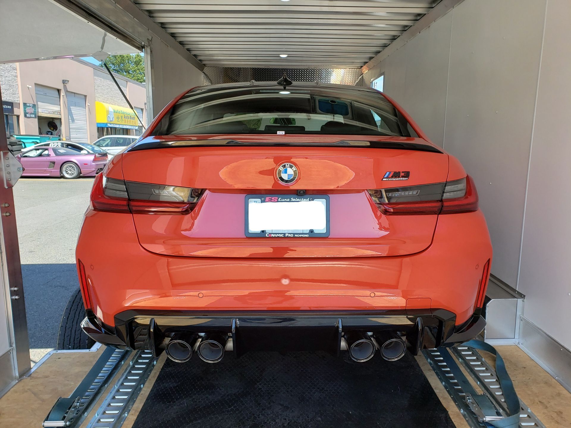 A red bmw m3 is parked in a trailer.
