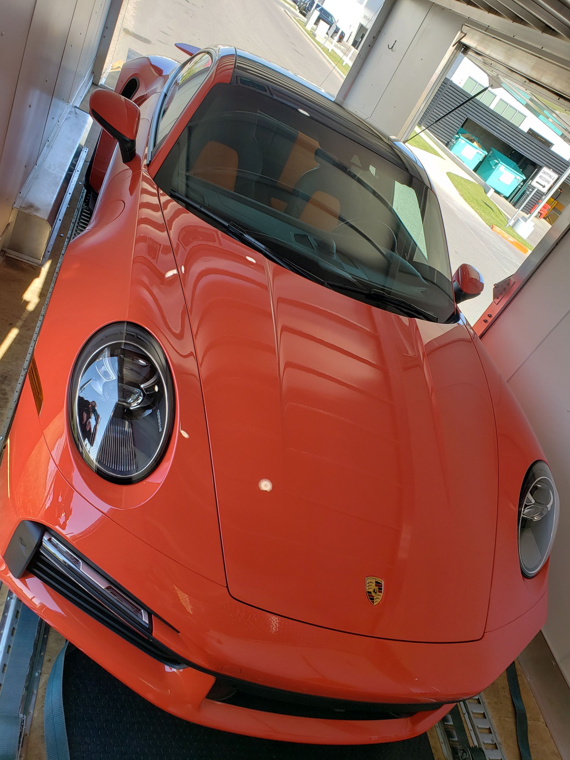 An orange sports car is parked in a garage