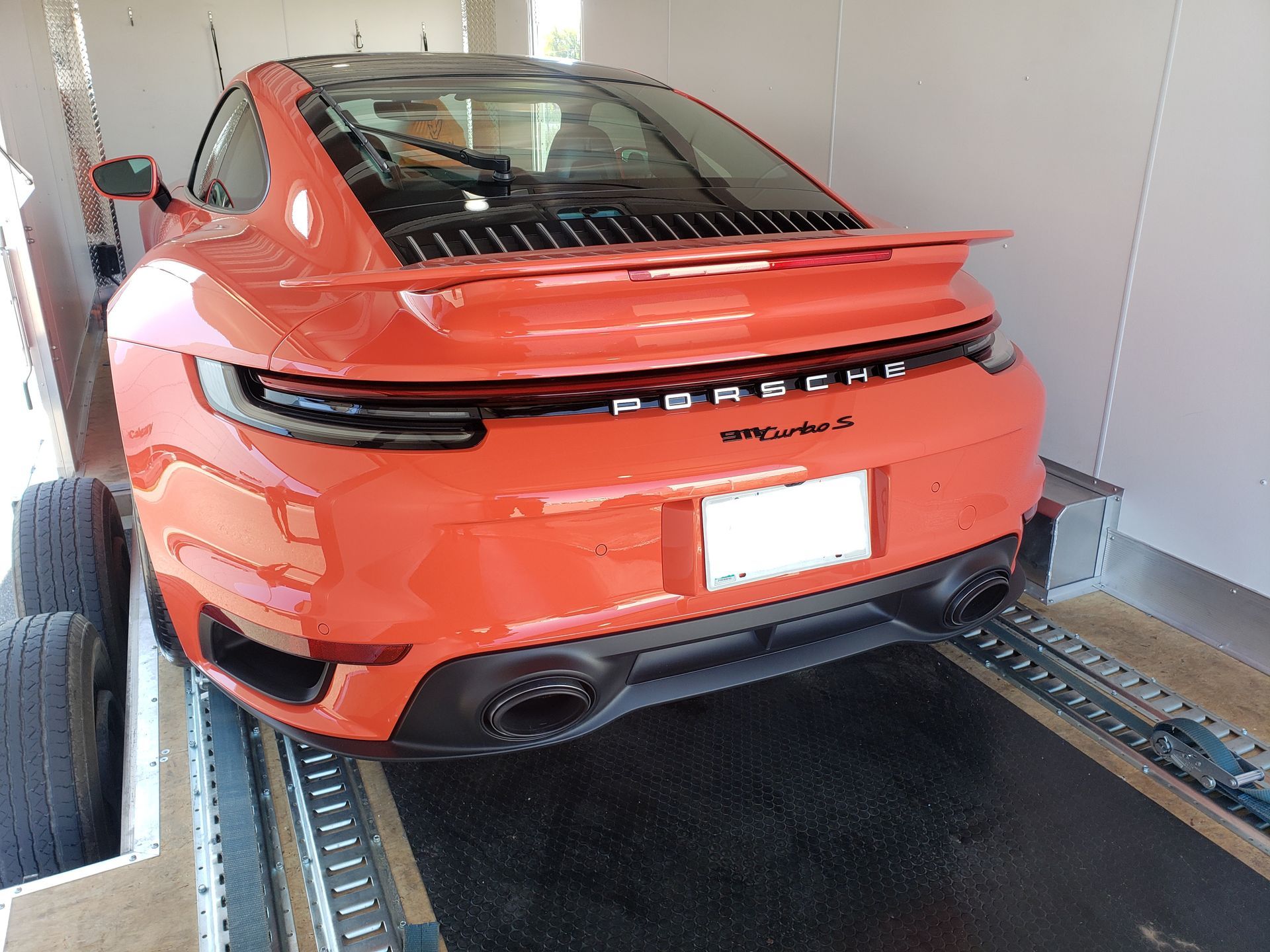 An orange porsche turbo s is parked in a garage