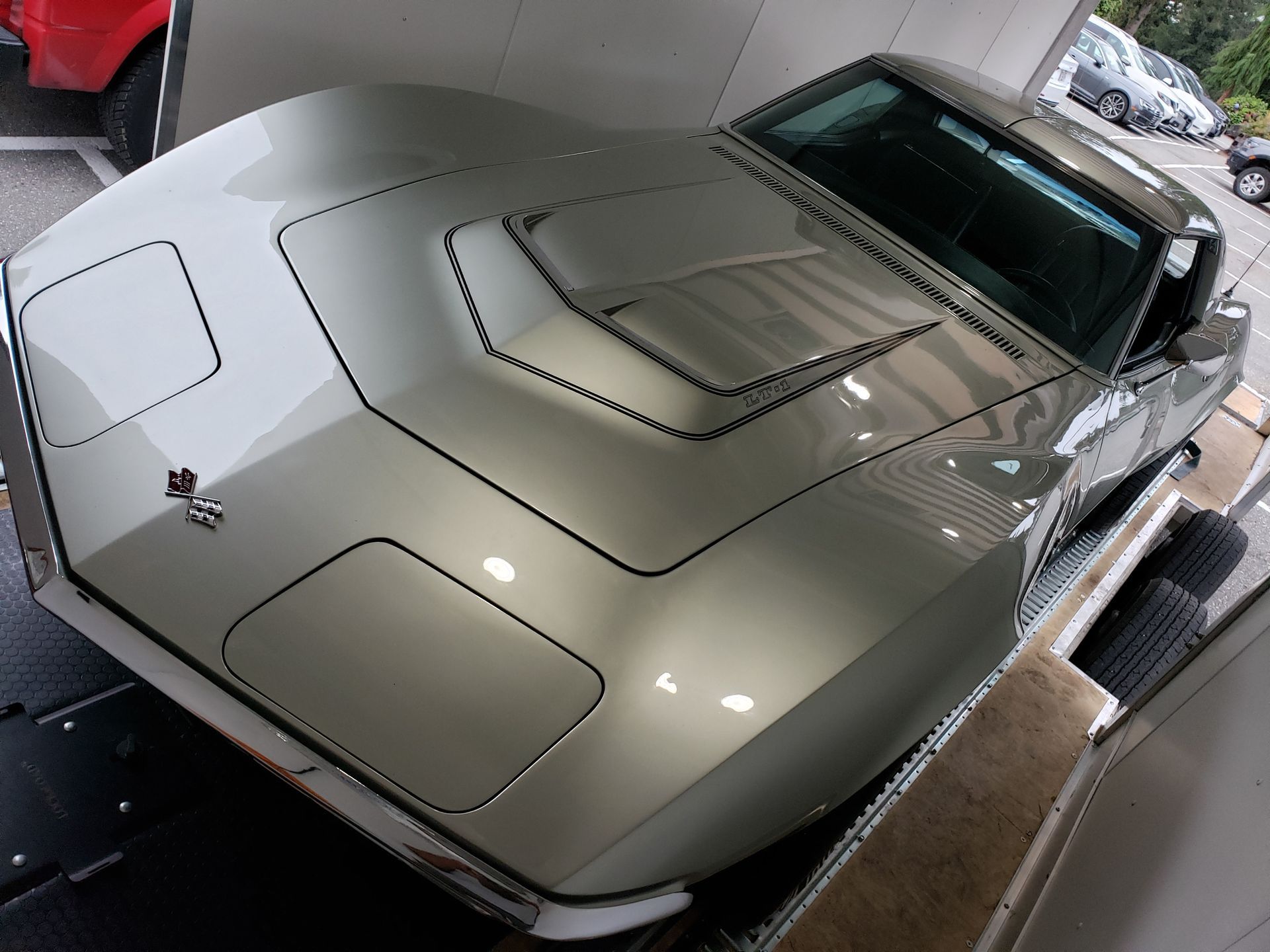 A silver corvette is parked in a garage