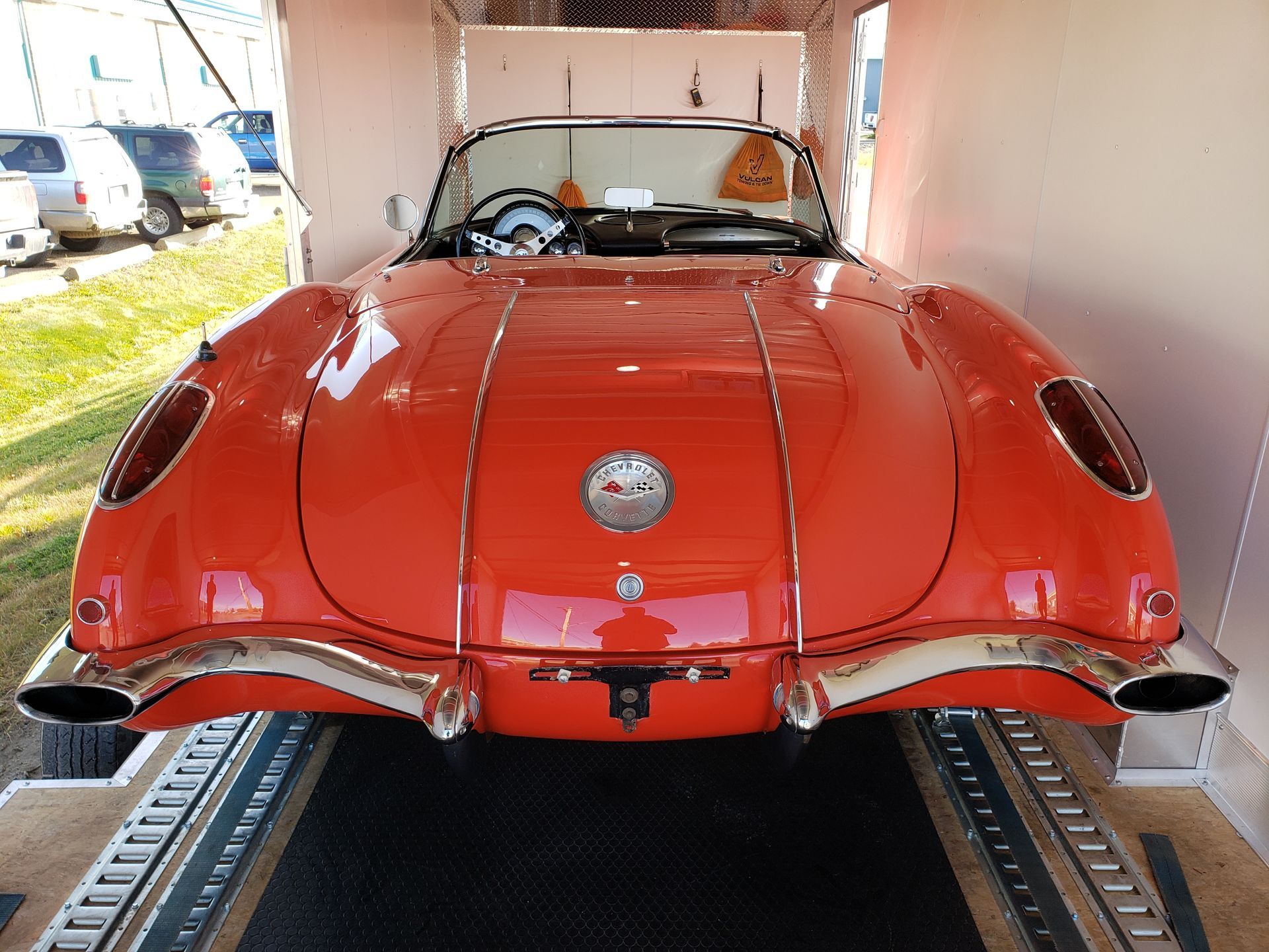 A red corvette is parked in a trailer.