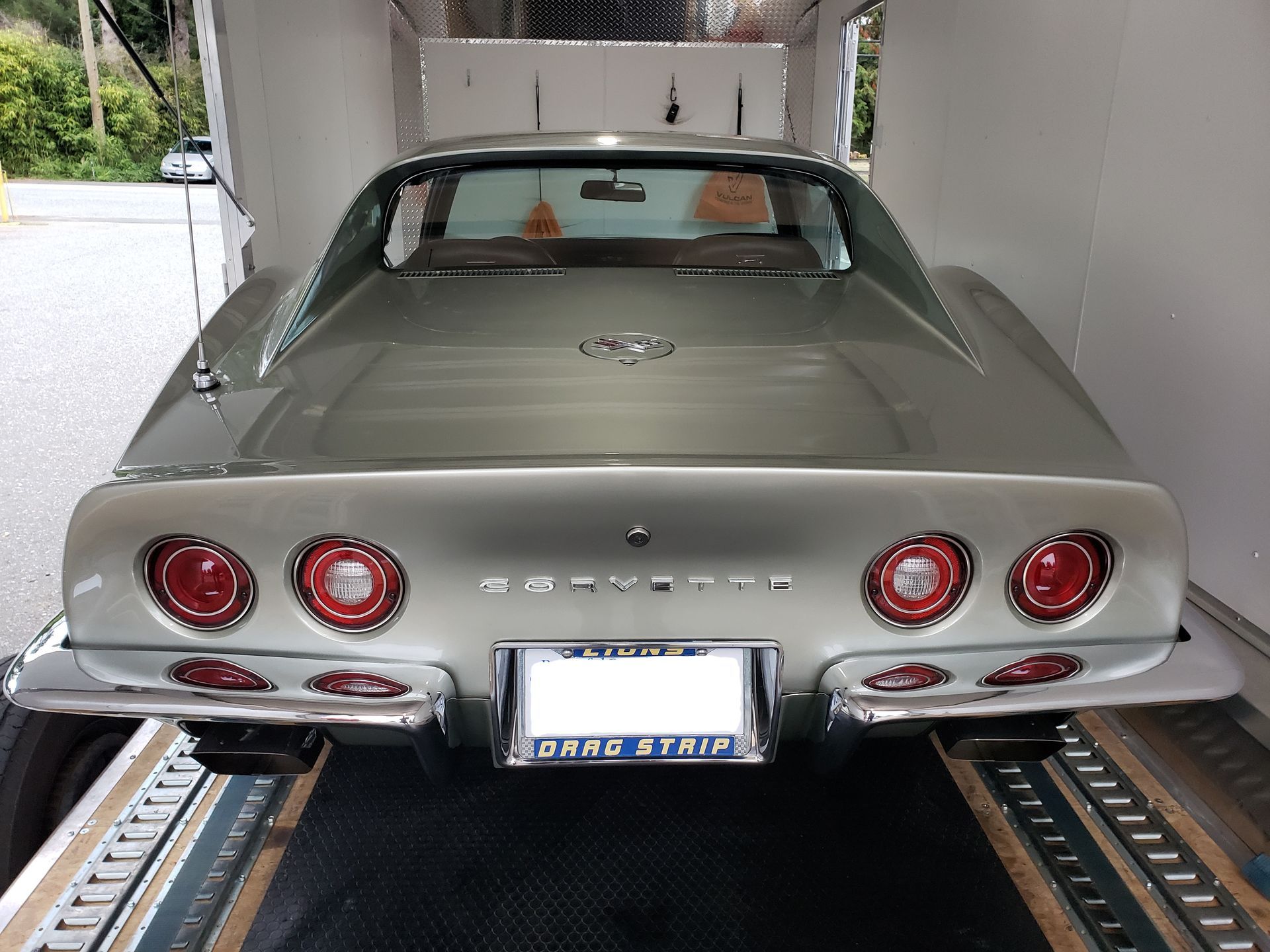 A silver corvette with a license plate that says grand strip