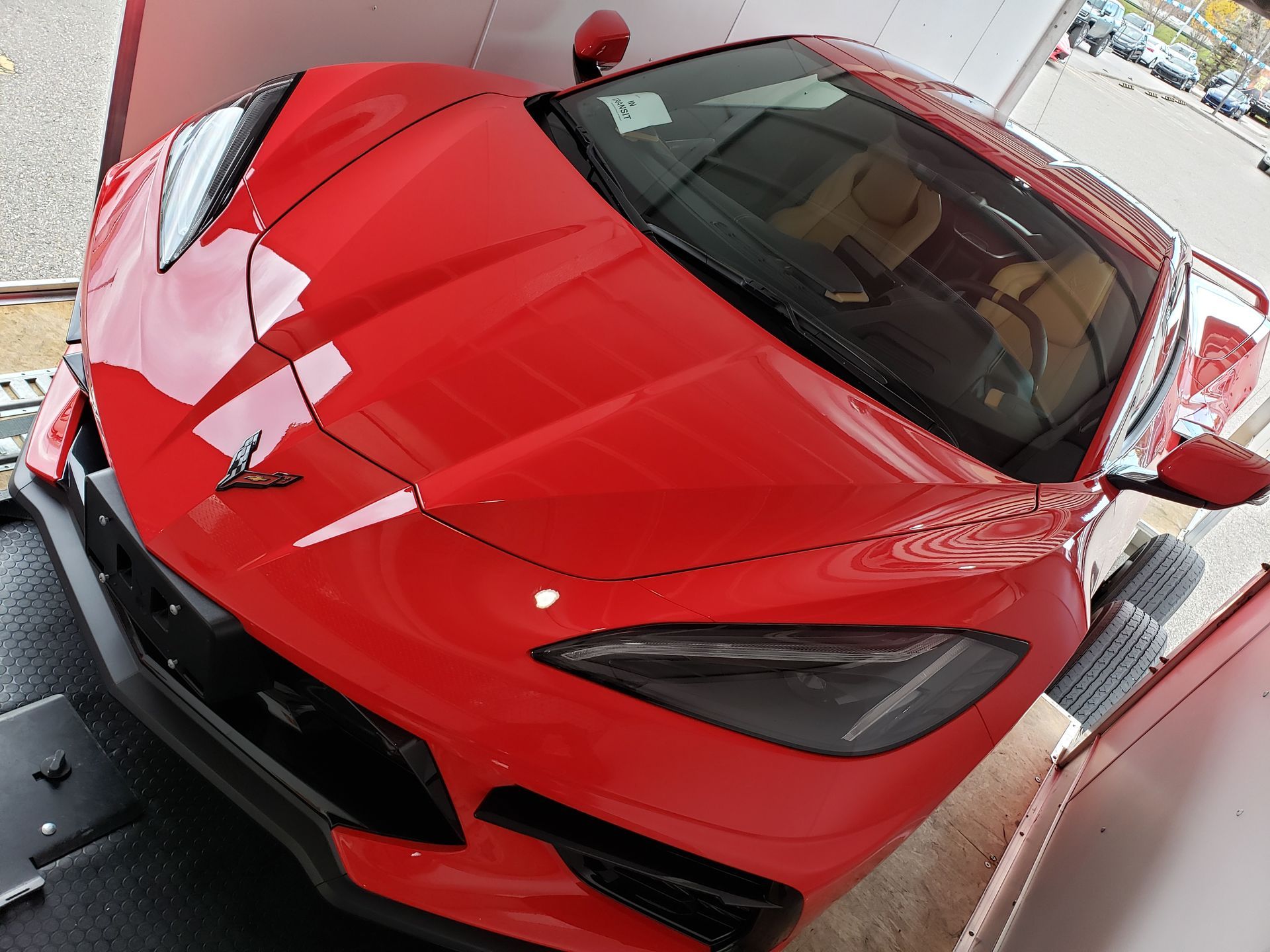 A red sports car is parked in a garage