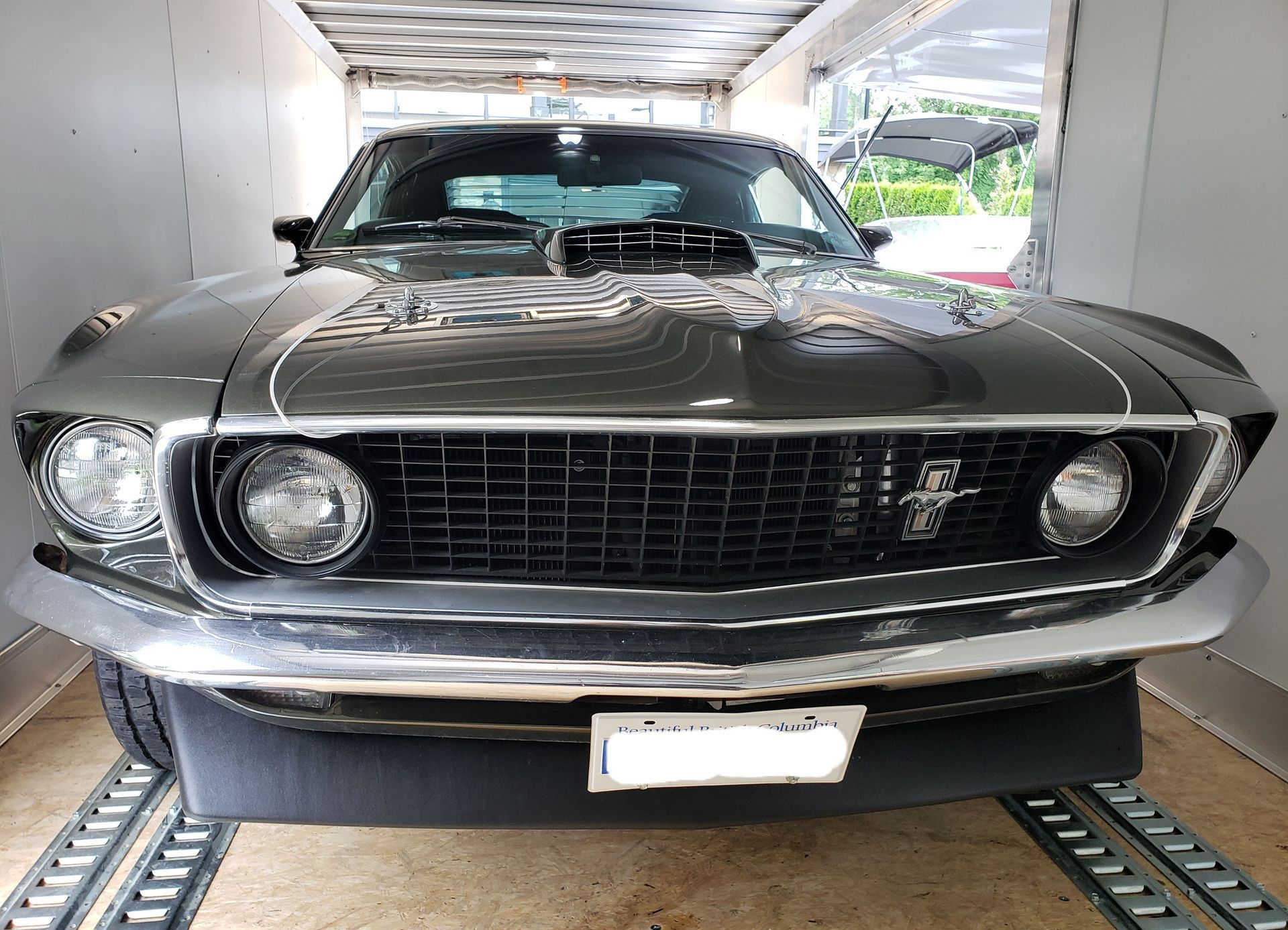 A black mustang is parked in a garage.