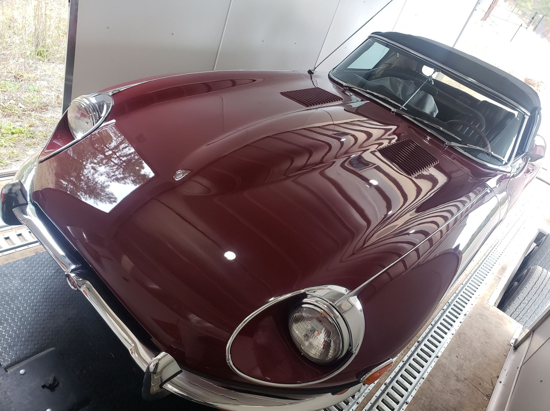 A red sports car is parked in a garage.
