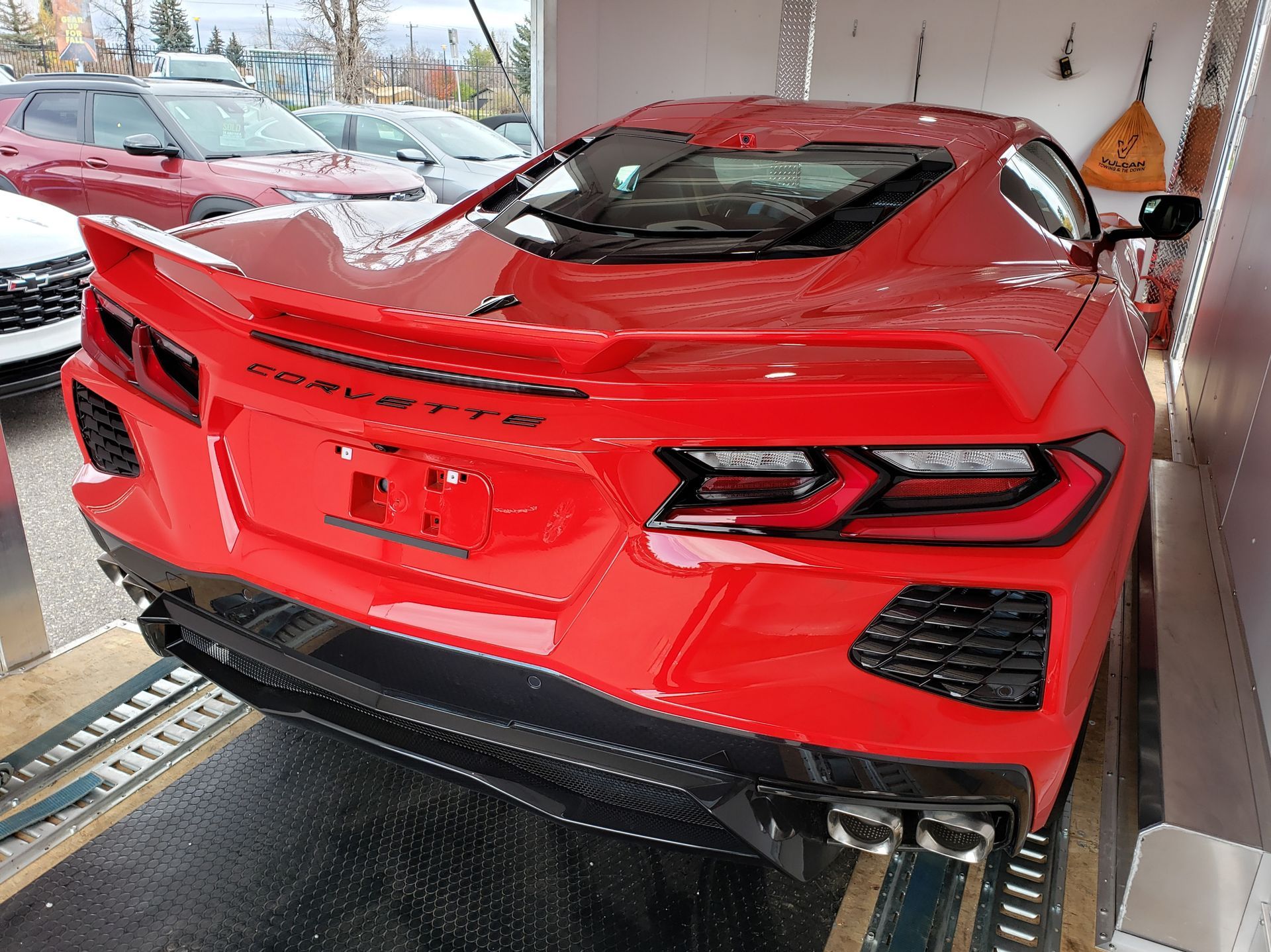 A red corvette is parked in a garage.