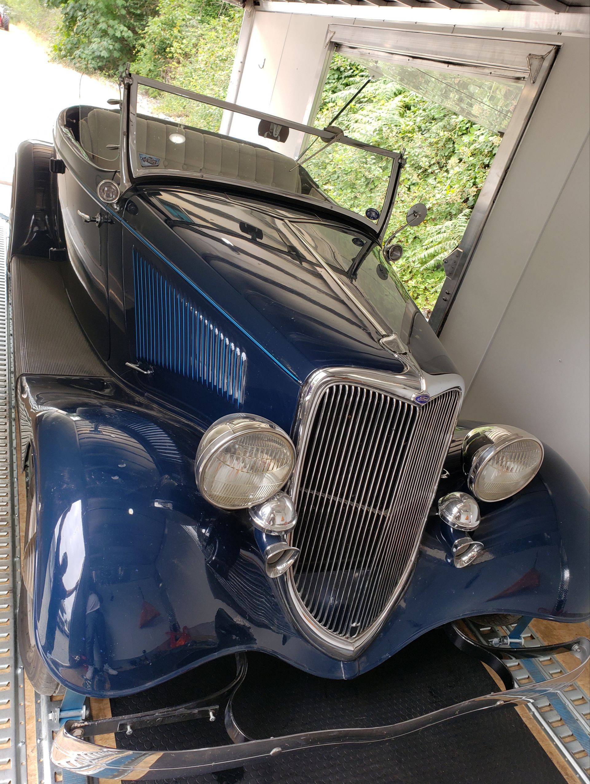 A blue car is sitting on top of a trailer