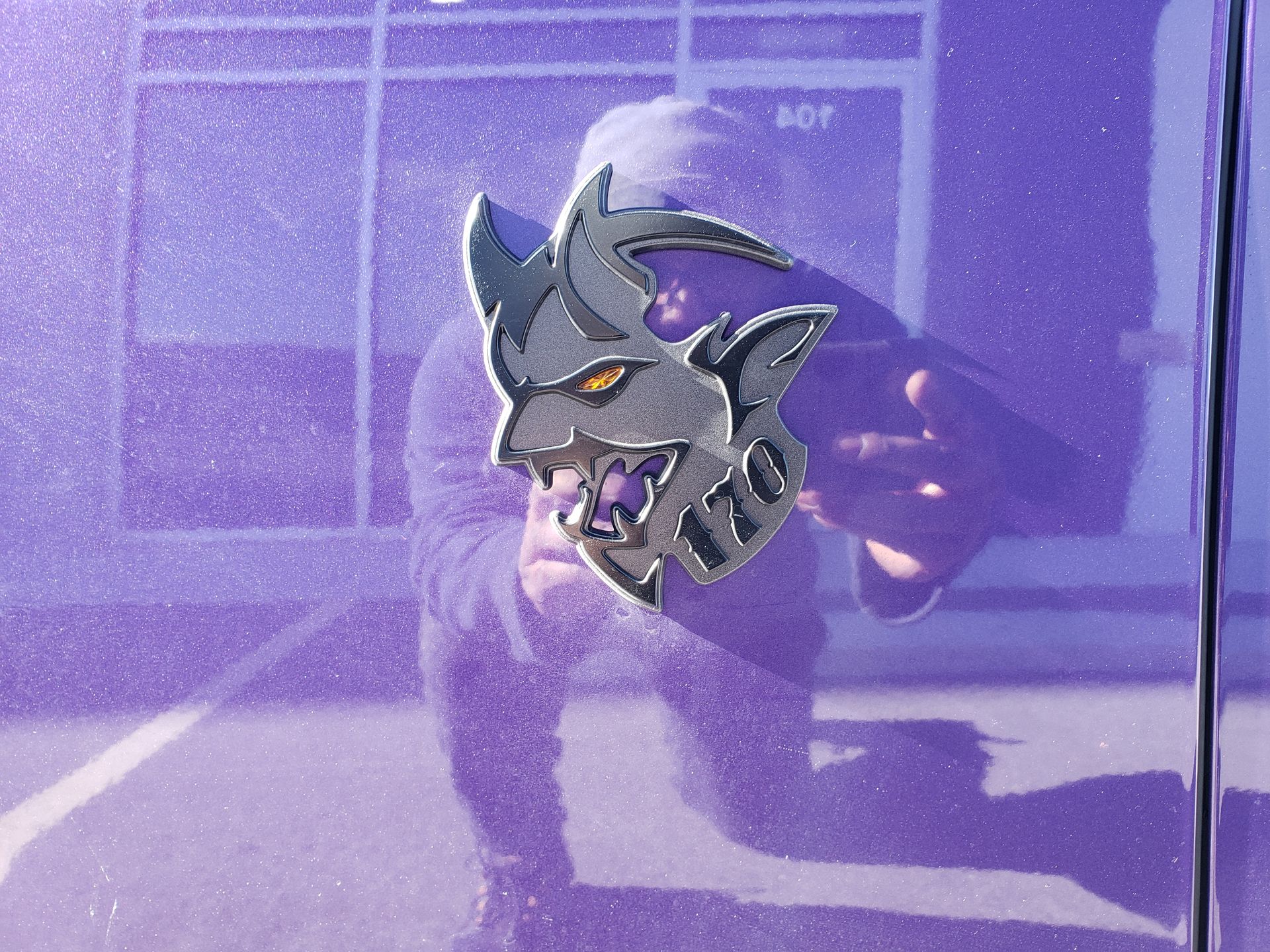 A purple car with a demon emblem on it