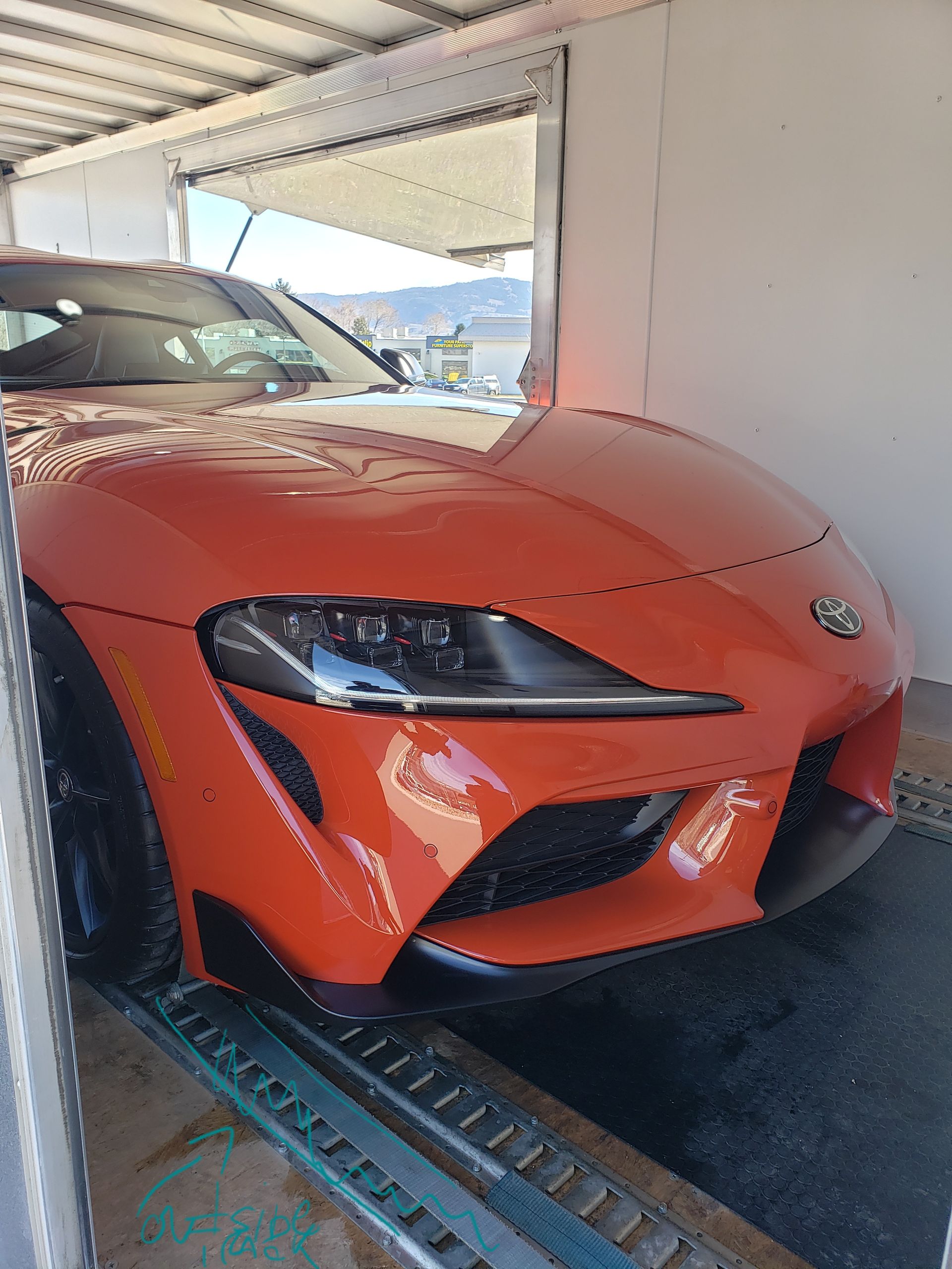 A red sports car is parked in a garage.