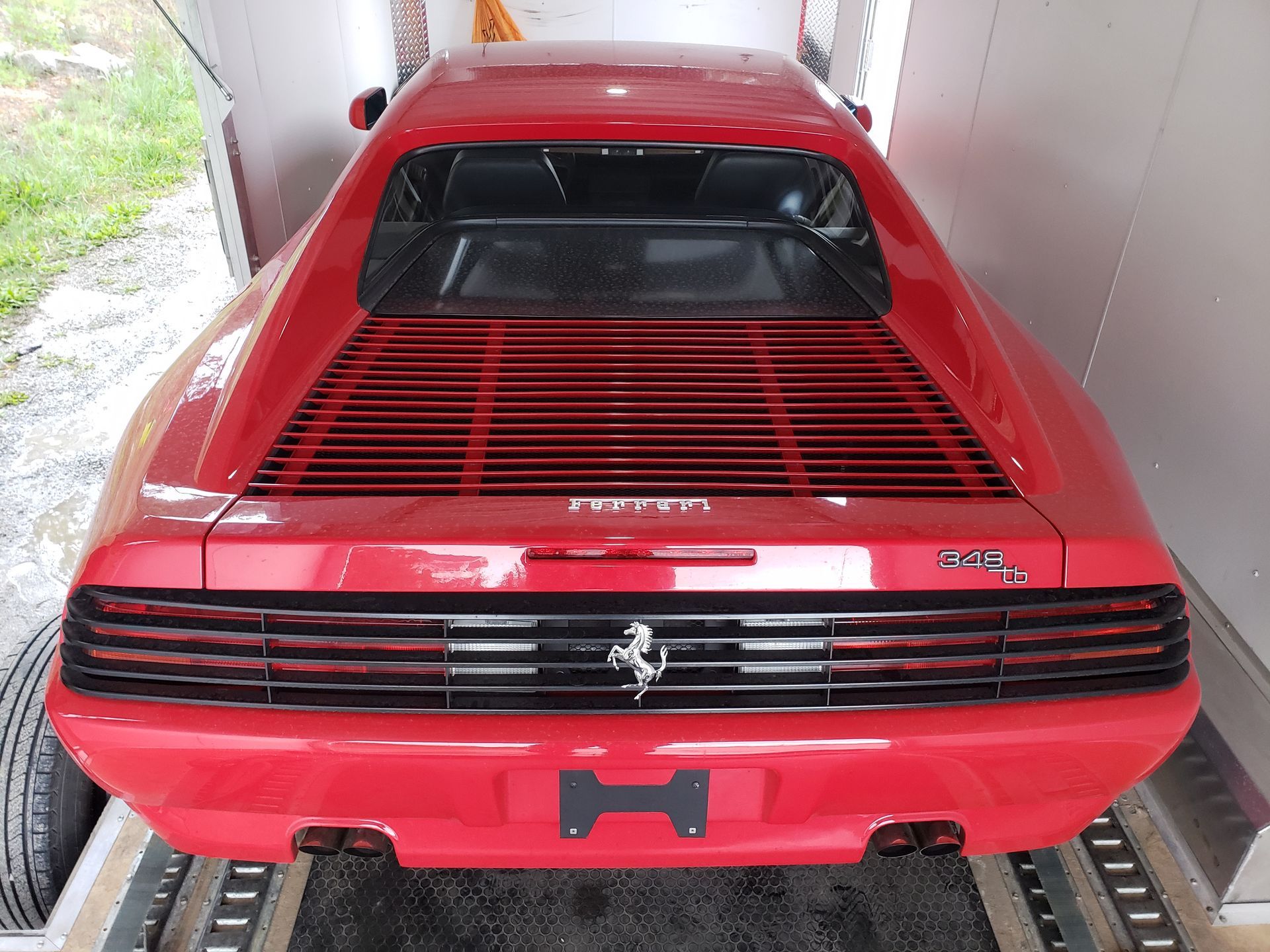 A red ferrari is parked in a garage