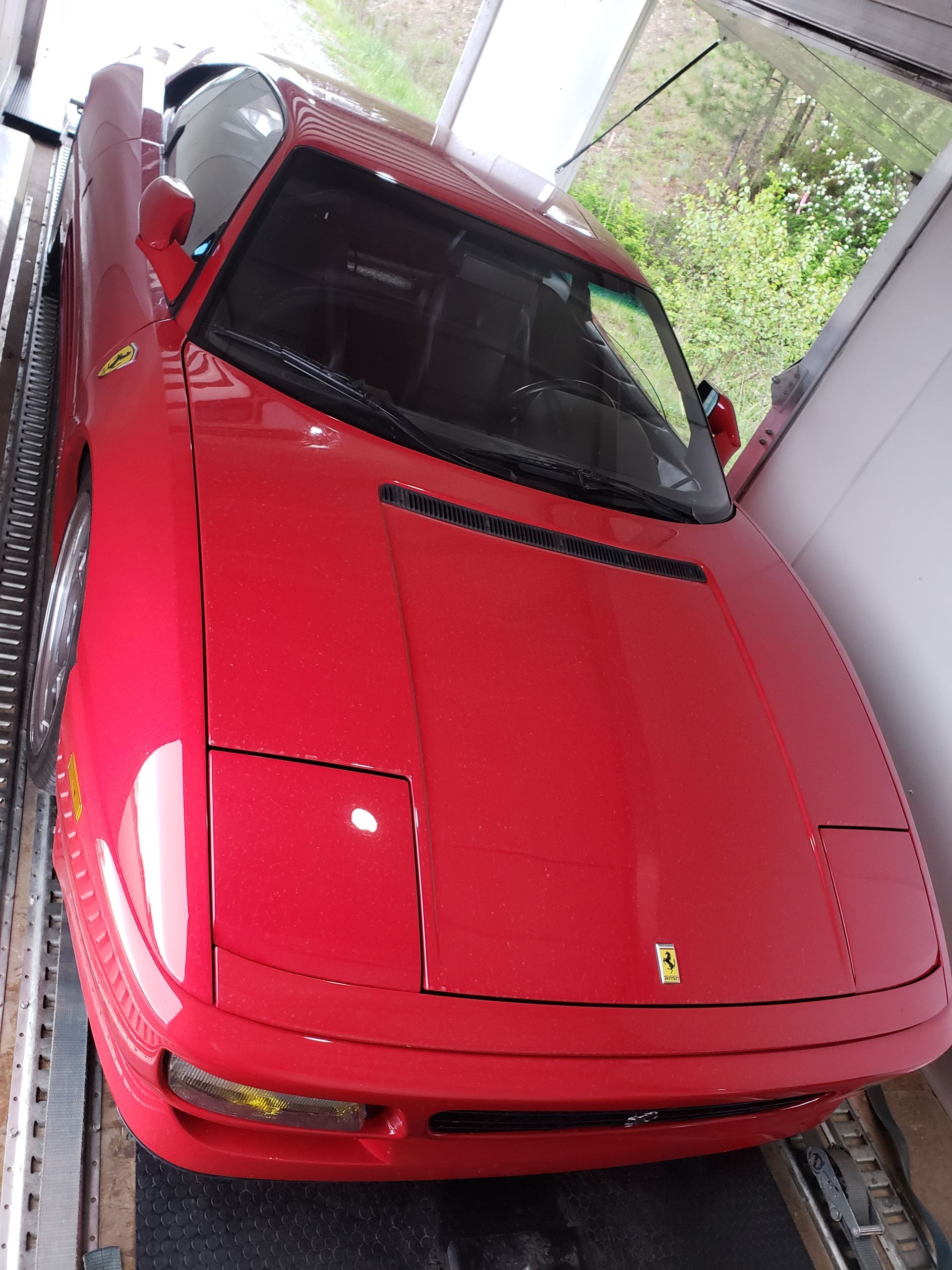 A red ferrari is parked in a garage