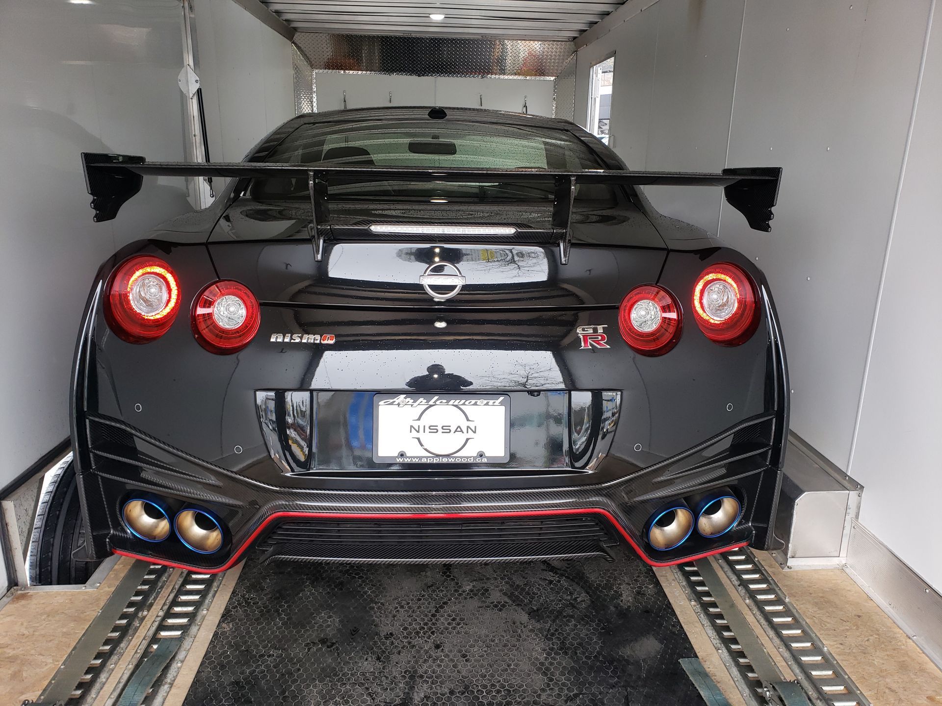 A black nissan gtr is parked in a trailer.
