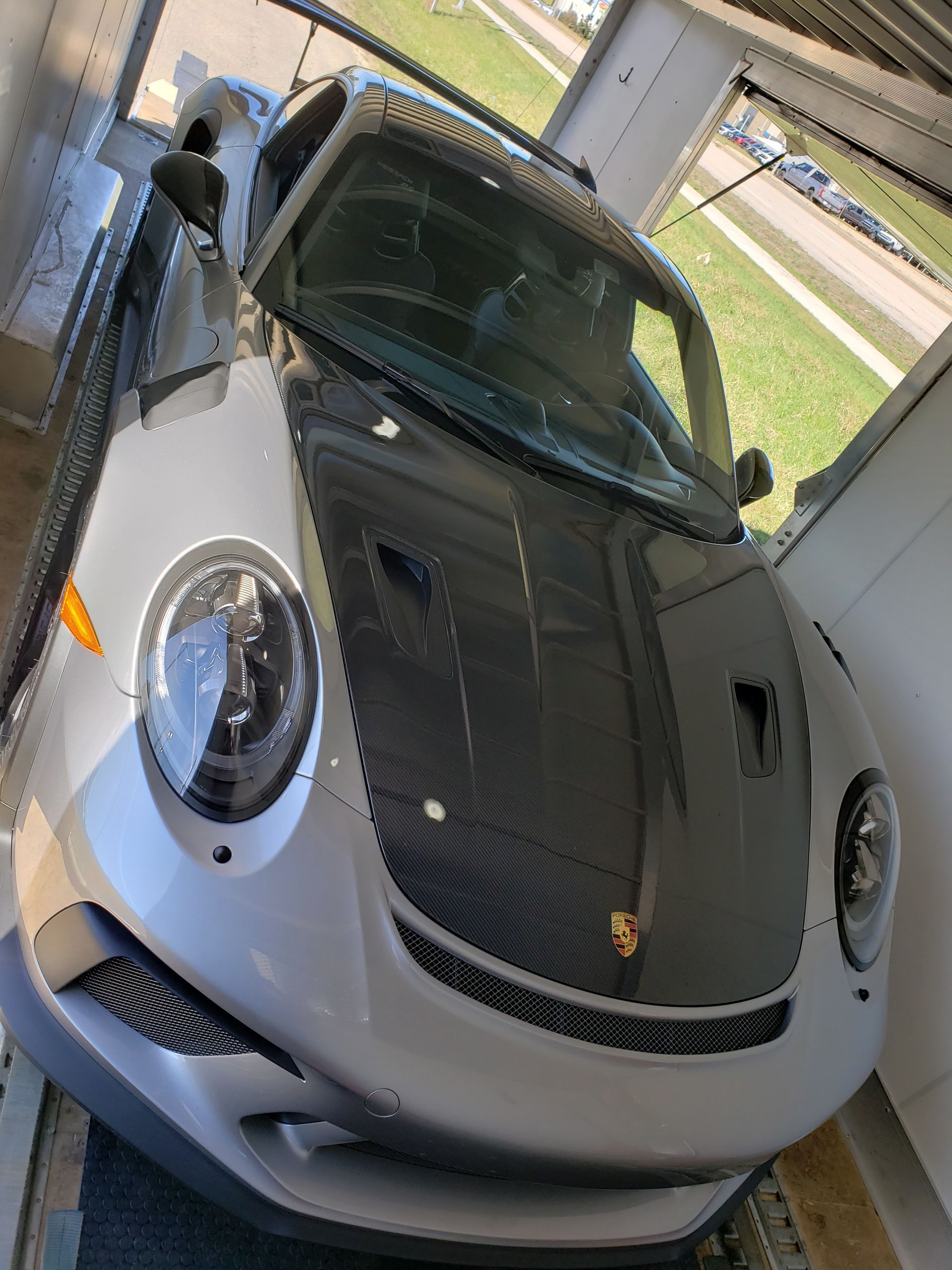A silver sports car is parked in a garage.