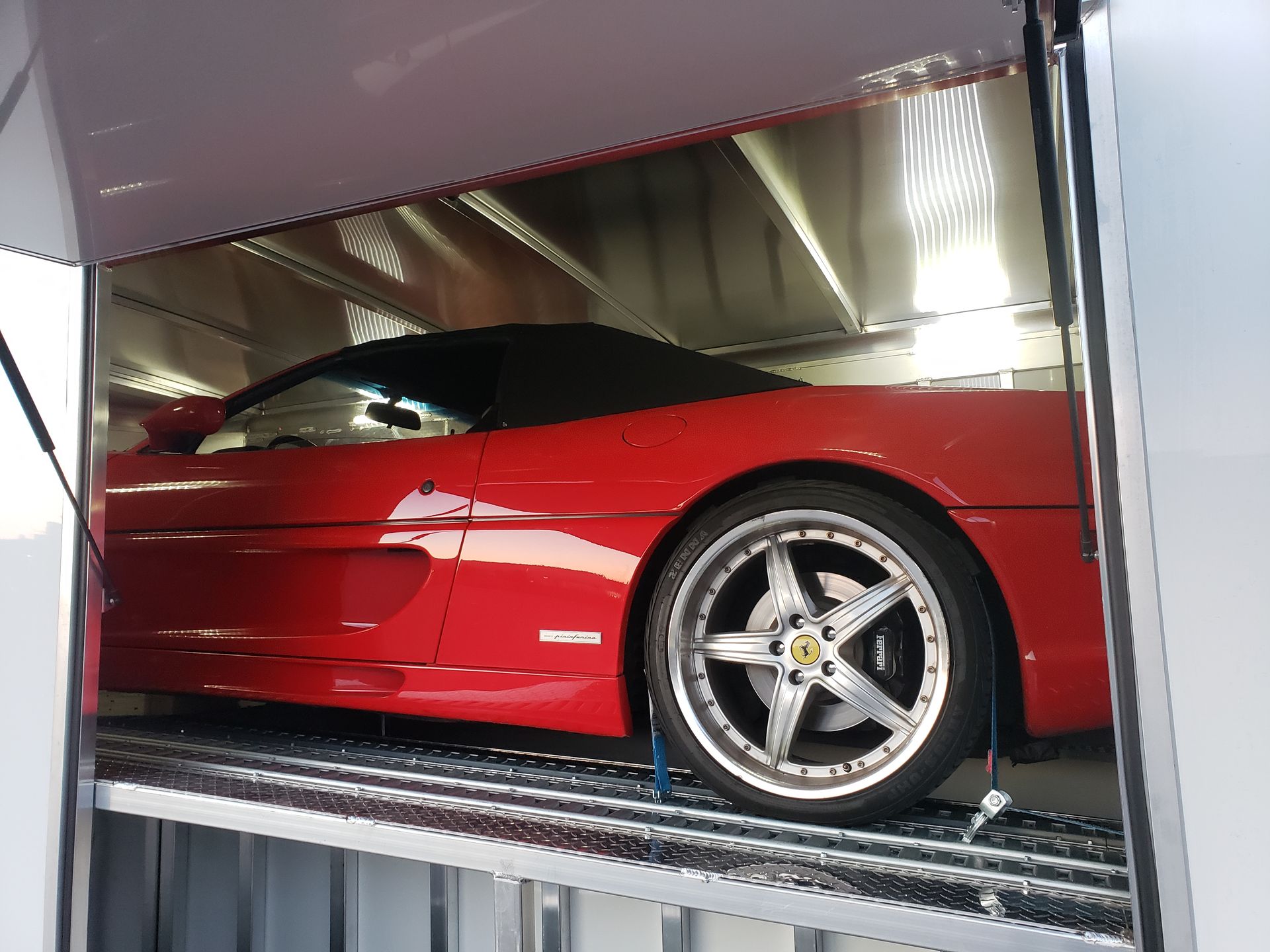 A red sports car is parked in a garage.