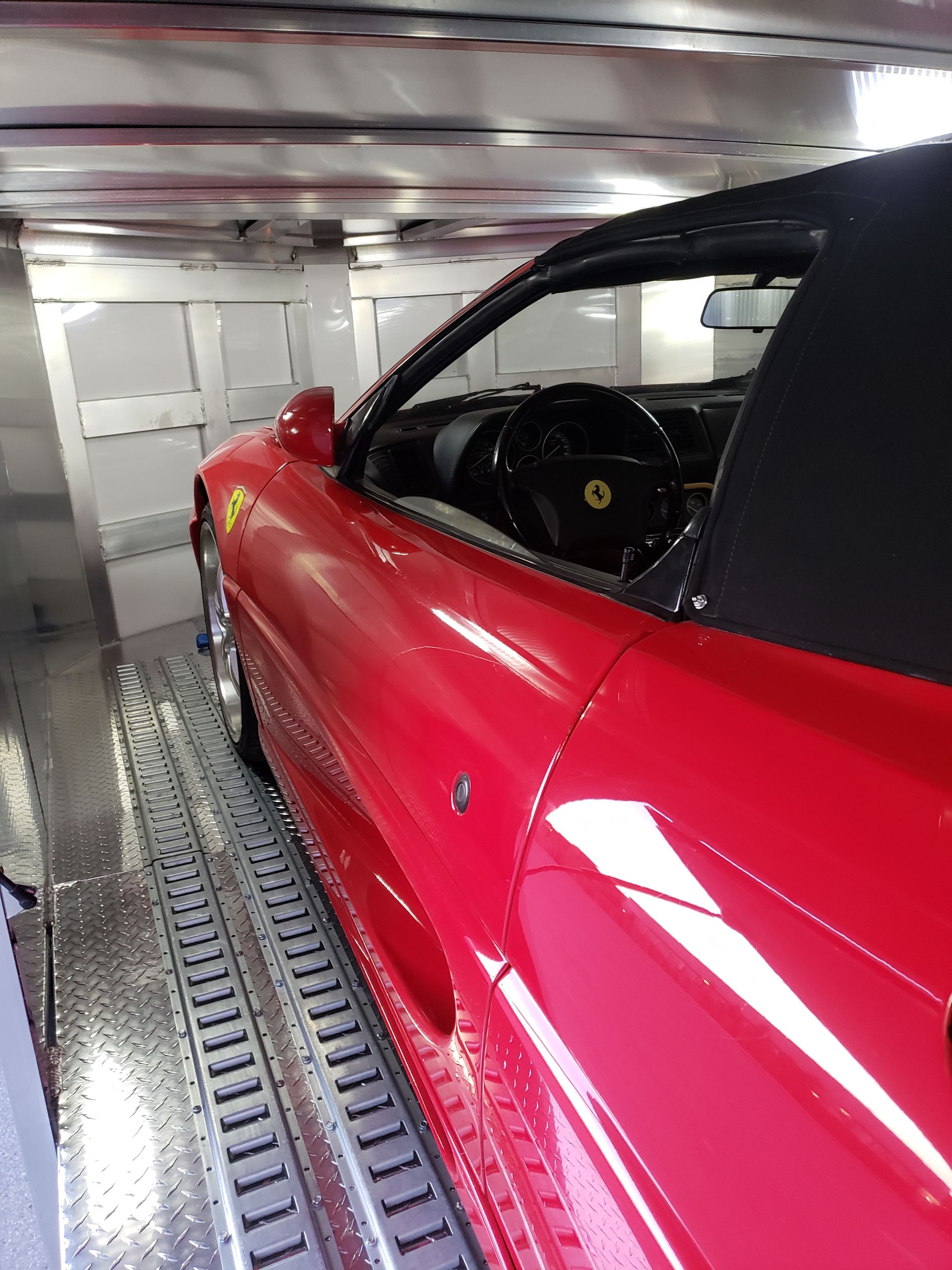 A red sports car is parked in a garage