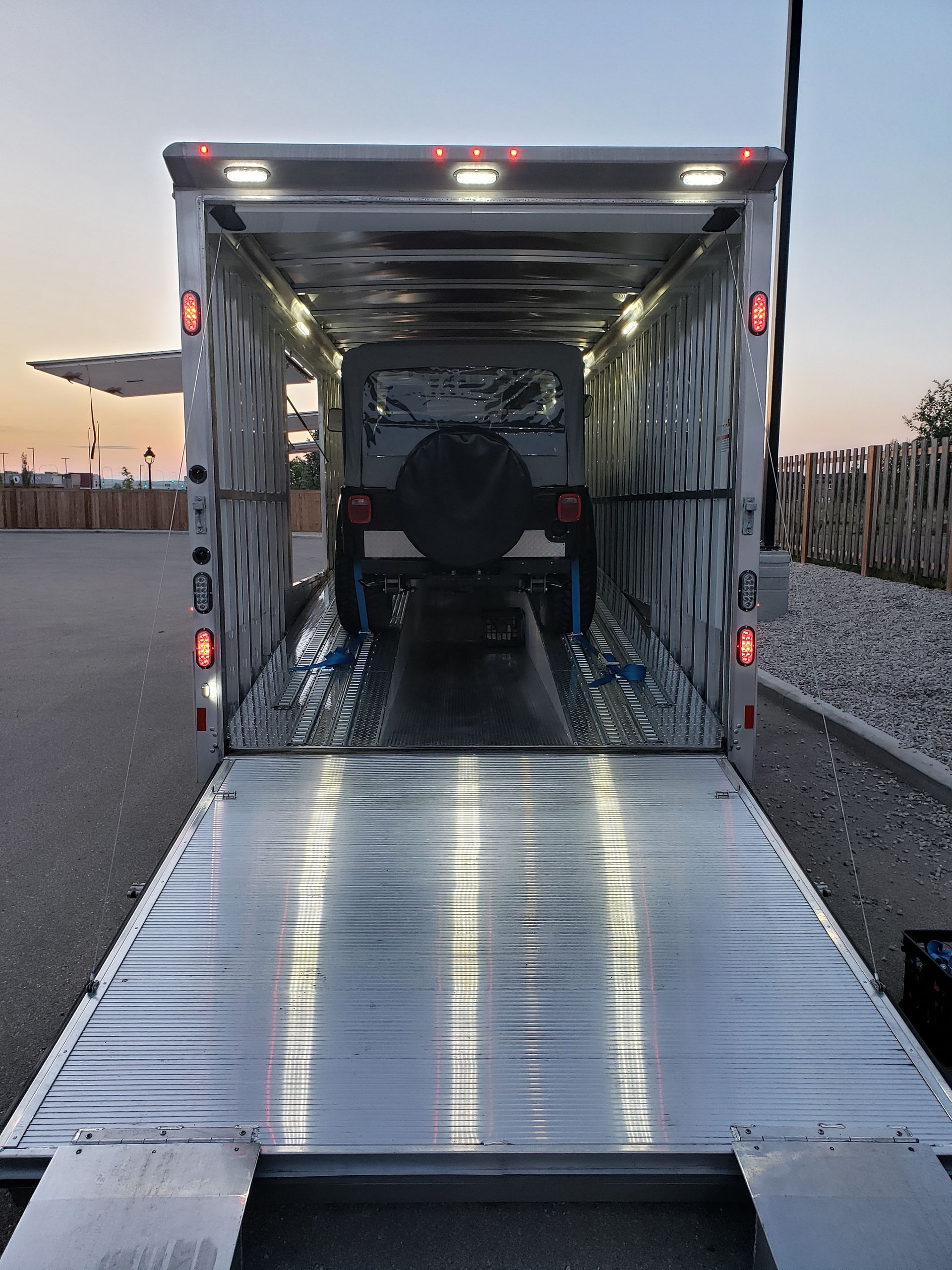 A jeep is being transported in a trailer.