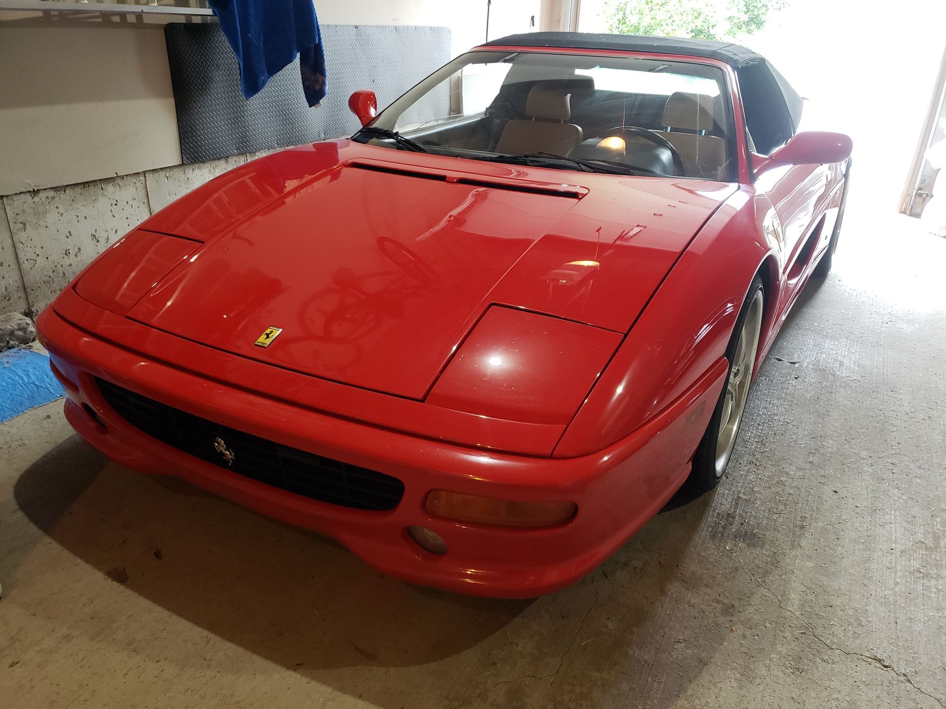 A red ferrari sports car is parked in a garage