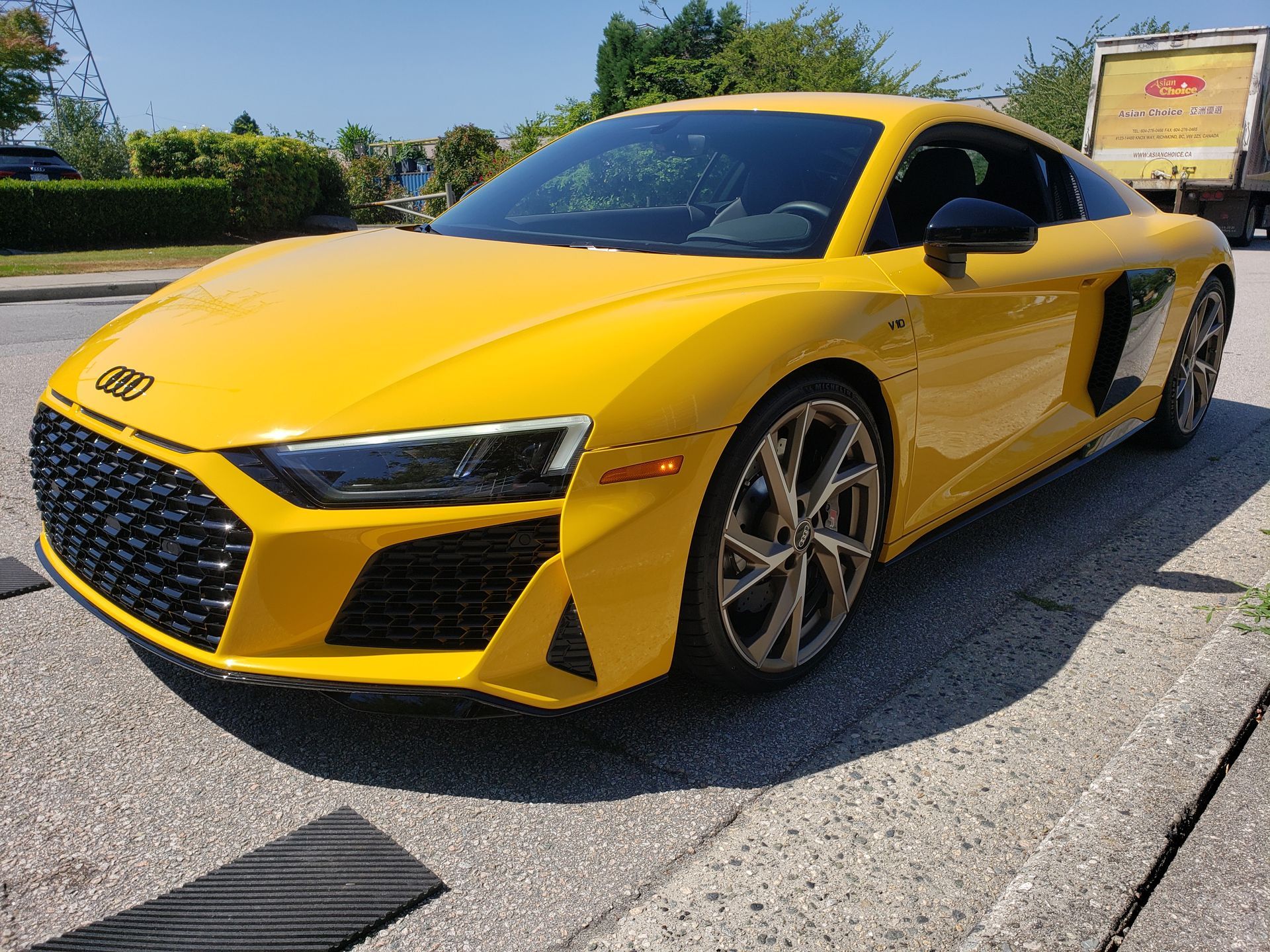 A yellow audi r8 is parked on the side of the road