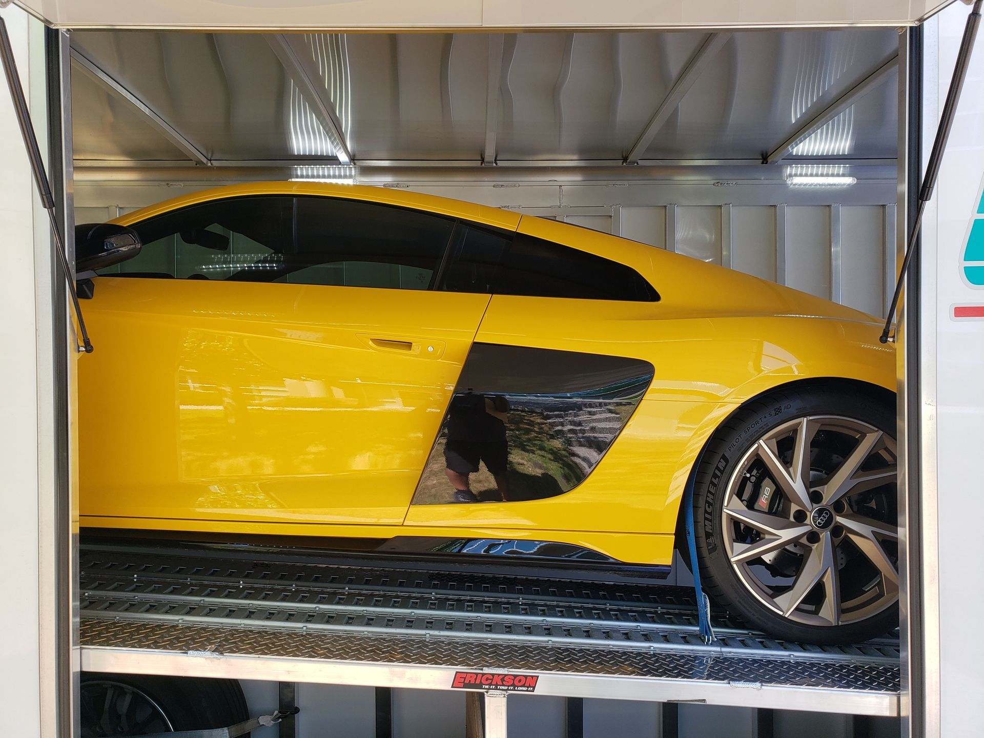 A yellow sports car is sitting on top of a trailer.