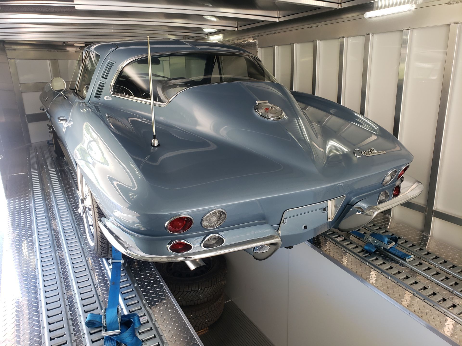 A blue corvette is parked in a warehouse
