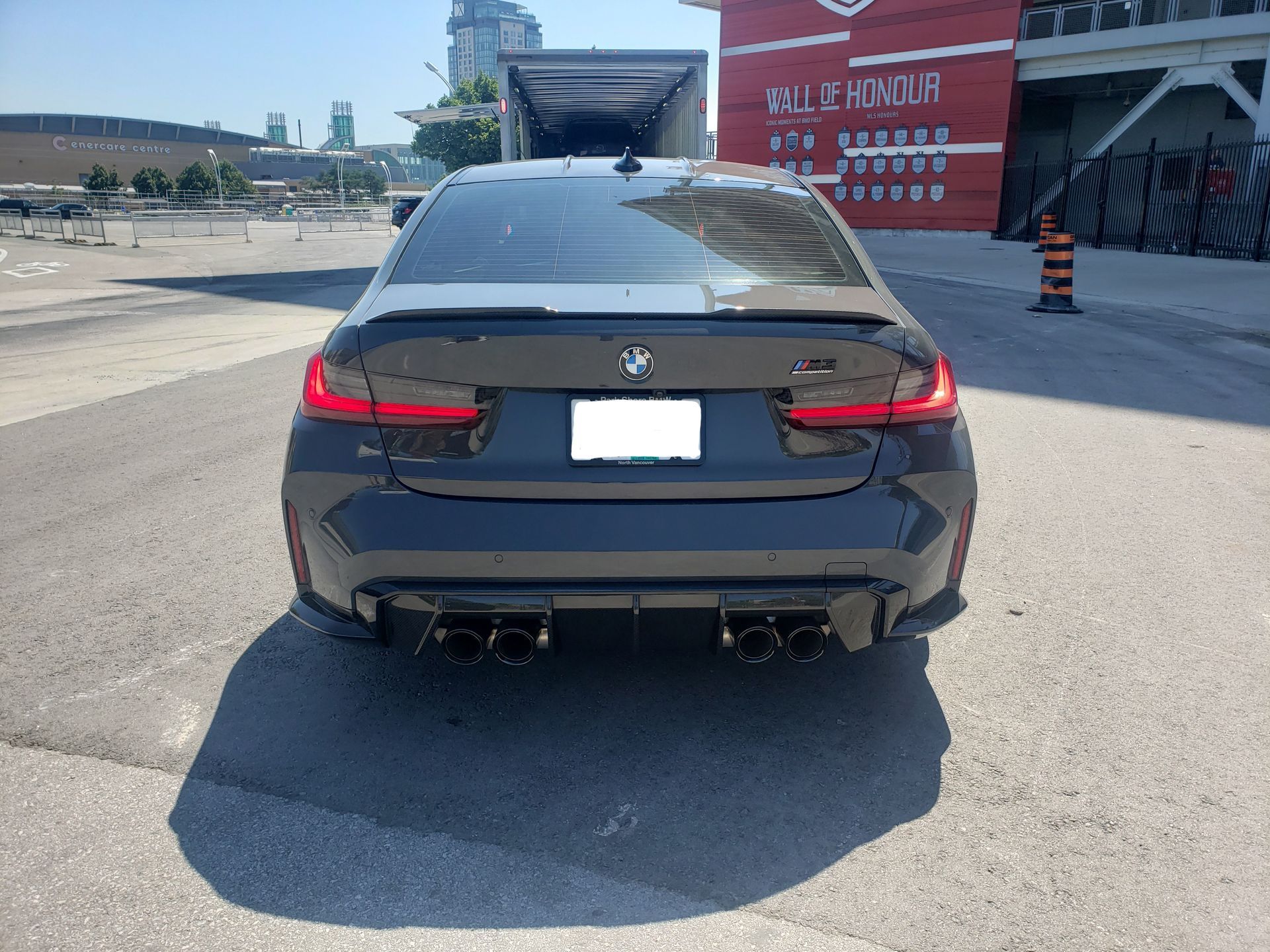 A black bmw is parked in a parking lot
