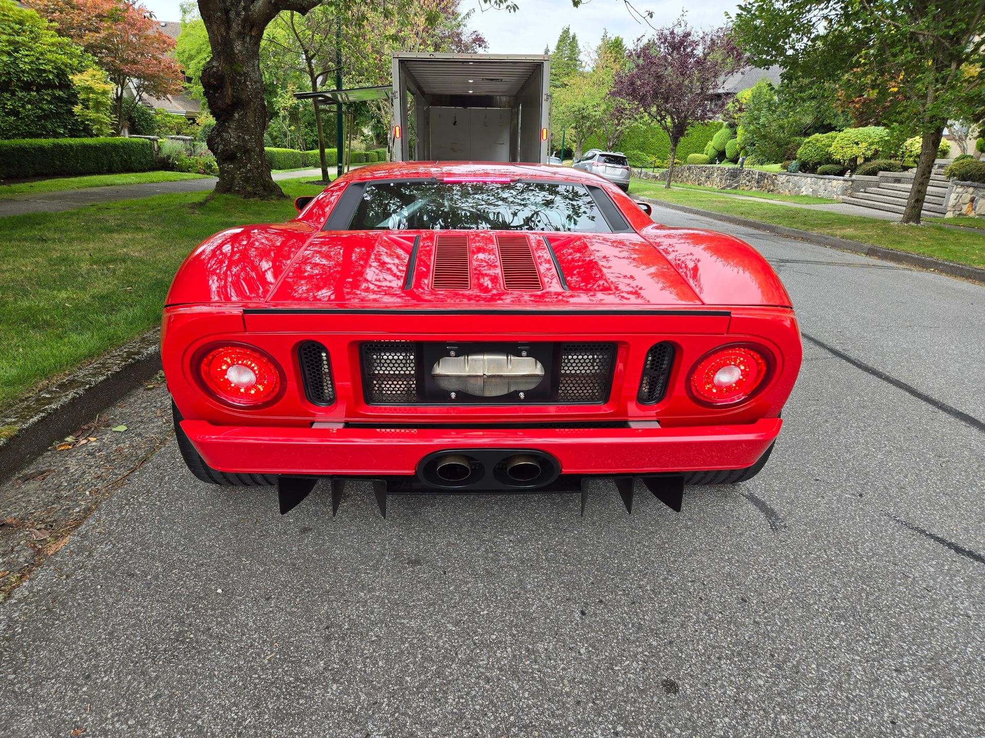 A red sports car is parked on the side of the road.