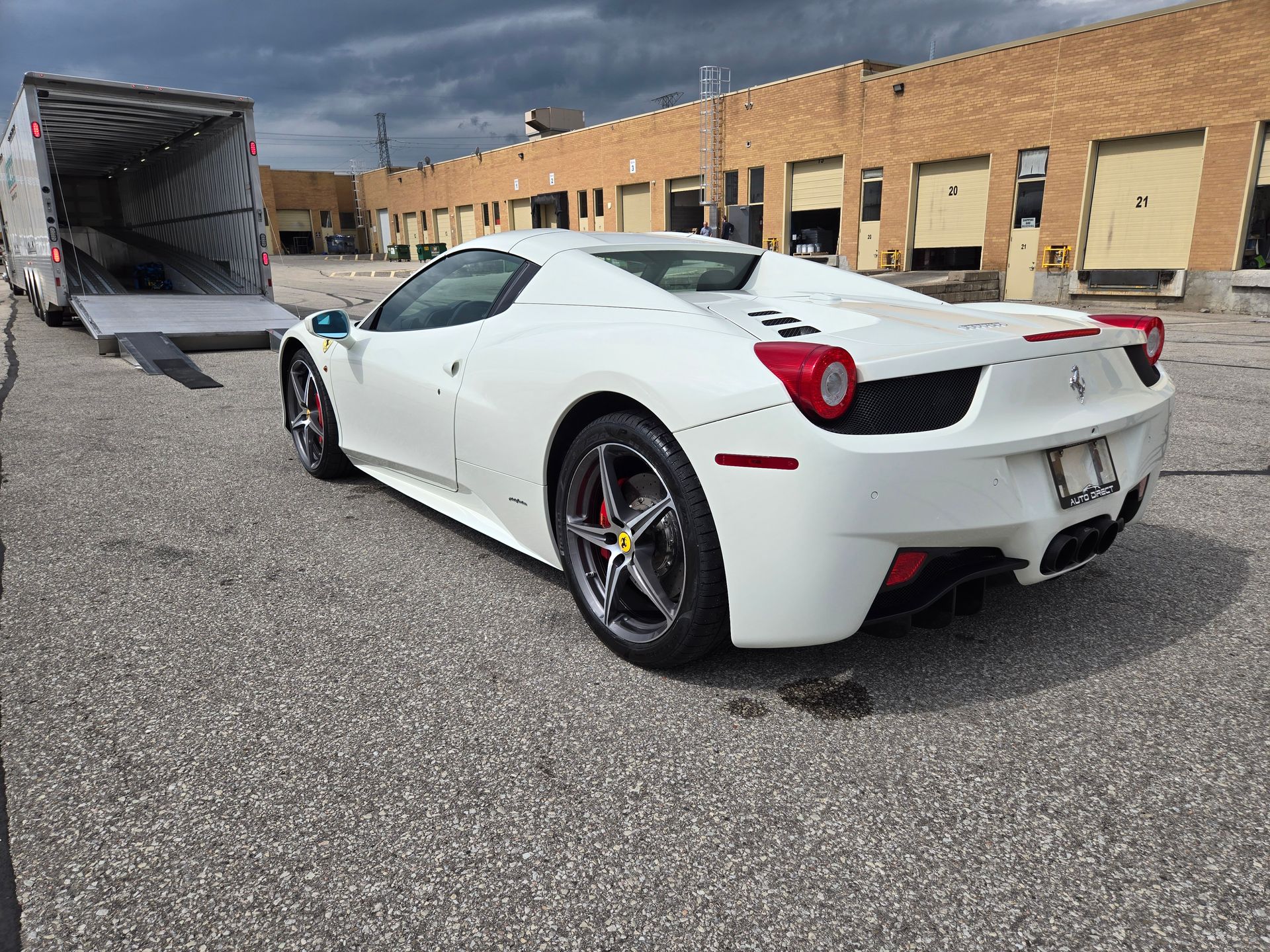 A white ferrari sports car is parked in front of a building