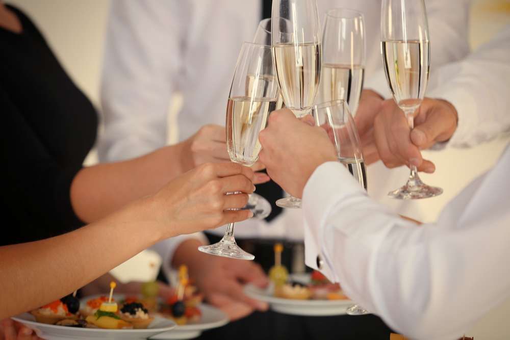 A group of people are toasting with champagne glasses at a party.
