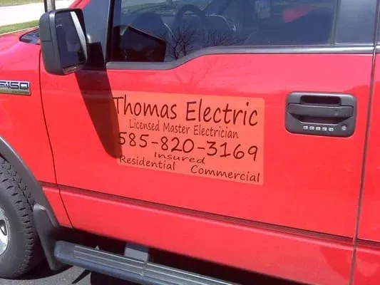 A red thomas electric truck is parked in a parking lot
