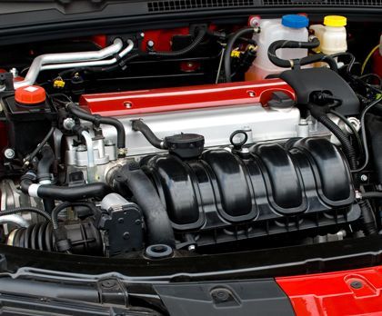 A close up of a car engine with the hood open