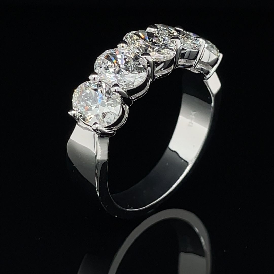 A white gold ring with diamonds on a black background.